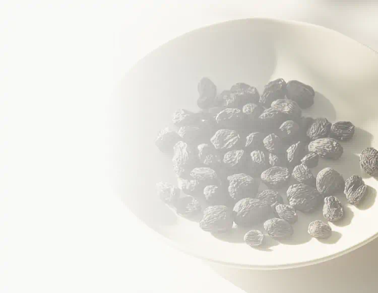 A bowl filled with small, dark, wrinkled Bakuchiol seeds