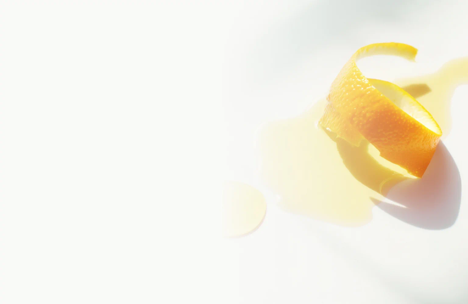 Orange peel curl beside a glossy pool of oil